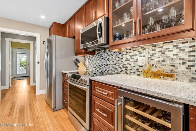 111 S 4th St, Fernandina Beach, FL 32034 - kitchen with appliances with stainless steel finishes, wine cooler, light wood-style floors, light stone countertops, and recessed lighting