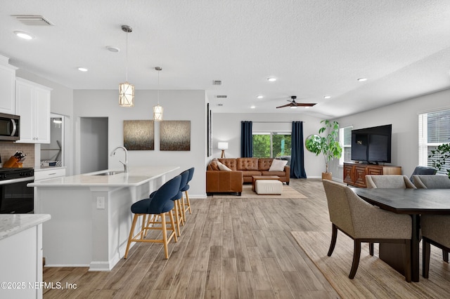 204 Bryson Dr, Fruit Cove, FL 32259 - kitchen featuring stainless steel appliances, open floor plan, light wood finished floors, recessed lighting, and a textured ceiling
