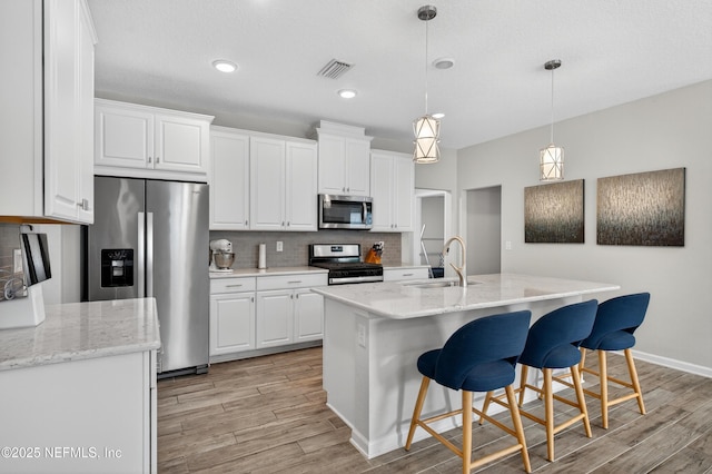 204 Bryson Dr, Fruit Cove, FL 32259 - kitchen with stainless steel appliances, light wood-type flooring, white cabinets, tasteful backsplash, and recessed lighting
