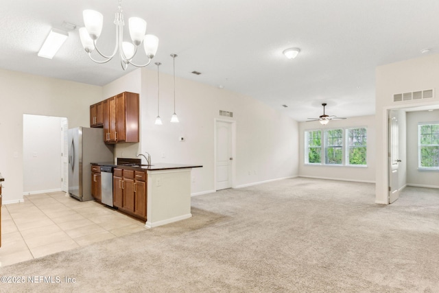 218 Larkin Pl Unit 110, Saint Johns, FL 32259 - kitchen featuring dark countertops, appliances with stainless steel finishes, brown cabinetry, a ceiling fan, and a chandelier