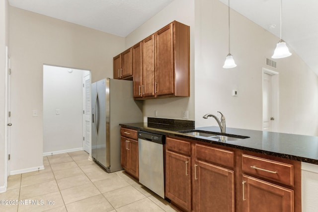 218 Larkin Pl Unit 110, Saint Johns, FL 32259 - kitchen featuring stainless steel appliances, brown cabinets, dark stone countertops, pendant lighting, and light tile patterned flooring