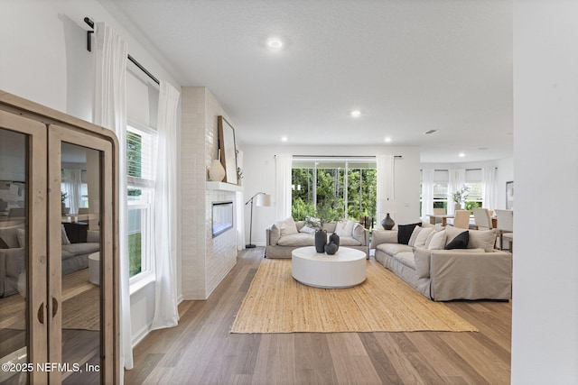 73 Ripple Rd, Saint Johns, FL 32095 - living area featuring a glass covered fireplace, wood finished floors, and recessed lighting