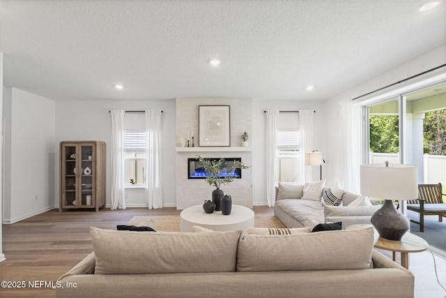 73 Ripple Rd, Saint Johns, FL 32095 - living area featuring recessed lighting, a large fireplace, wood finished floors, and a textured ceiling