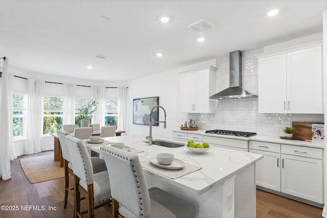 73 Ripple Rd, Saint Johns, FL 32095 - kitchen with wall chimney exhaust hood, gas cooktop, a kitchen breakfast bar, wood finished floors, and recessed lighting