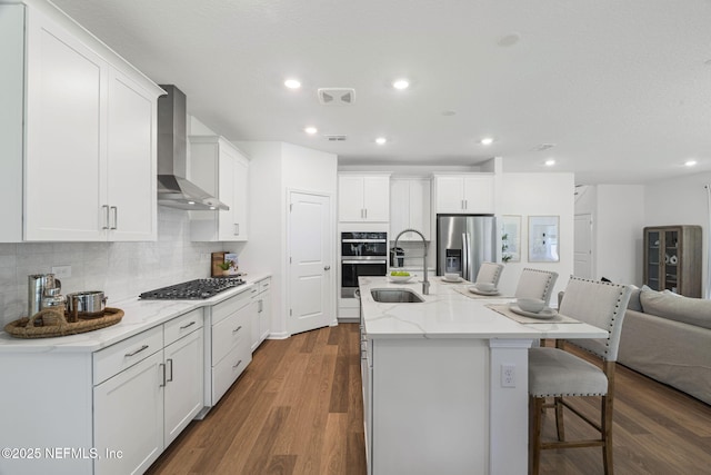 73 Ripple Rd, Saint Johns, FL 32095 - kitchen with appliances with stainless steel finishes, wall chimney exhaust hood, open floor plan, decorative backsplash, and white cabinetry