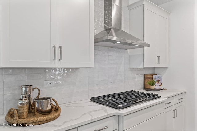 73 Ripple Rd, Saint Johns, FL 32095 - kitchen with wall chimney range hood, stainless steel gas stovetop, tasteful backsplash, white cabinetry, and light stone countertops