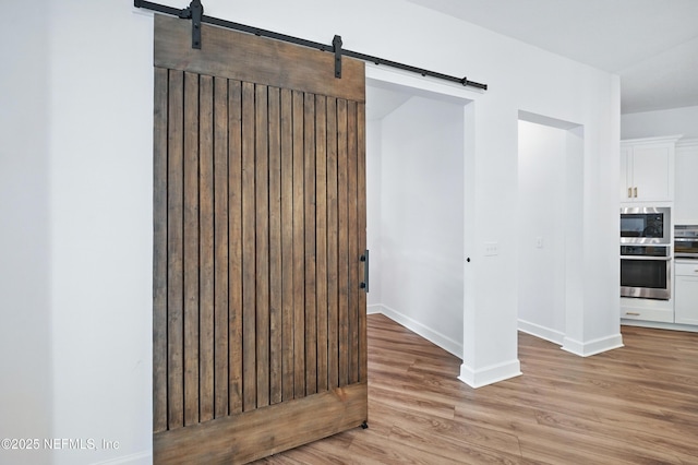 959 Crosswater Lake Dr, Ponte Vedra, FL 32081 - empty room with a barn door and light wood-style flooring
