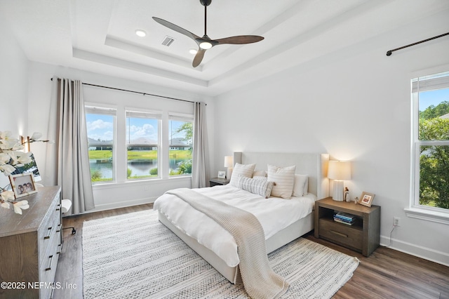 959 Crosswater Lake Dr, Ponte Vedra, FL 32081 - bedroom with wood finished floors, a raised ceiling, ceiling fan, and a water view