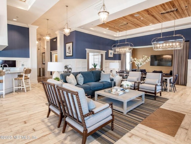 386 Whirlwind Pl, Saint Johns, FL 32095 - living room featuring a decorative wall, ornamental molding, wainscoting, a tray ceiling, and wood finished floors