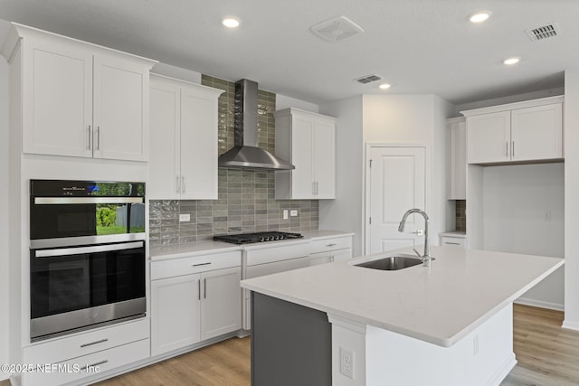 386 Whirlwind Pl, Saint Johns, FL 32095 - kitchen featuring wall chimney exhaust hood, stainless steel appliances, white cabinets, light wood-type flooring, and recessed lighting