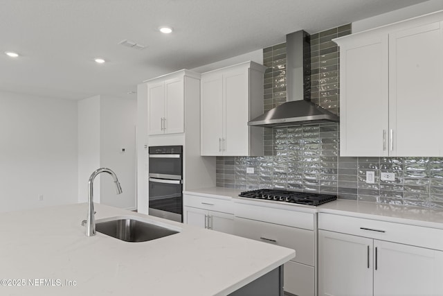386 Whirlwind Pl, Saint Johns, FL 32095 - kitchen featuring wall chimney exhaust hood, gas cooktop, double oven, backsplash, and white cabinets