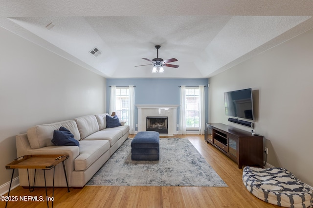 4521 Deep River Way E, Jacksonville, FL 32224 - living area with ceiling fan, light wood-style flooring, a textured ceiling, and a premium fireplace