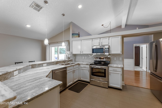 4521 Deep River Way E, Jacksonville, FL 32224 - kitchen featuring stainless steel appliances, white cabinets, decorative backsplash, hanging light fixtures, and light stone counters