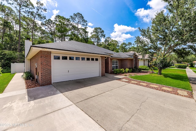 4521 Deep River Way E, Jacksonville, FL 32224 - view of front of house with brick siding, driveway, an attached garage, and a chimney
