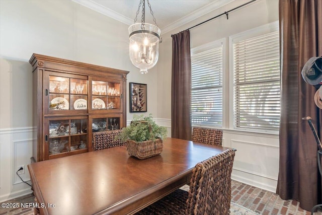 1060 Meadow View Ln, Saint Augustine, FL 32092 - dining space with a chandelier, a decorative wall, brick flooring, ornamental molding, and wainscoting