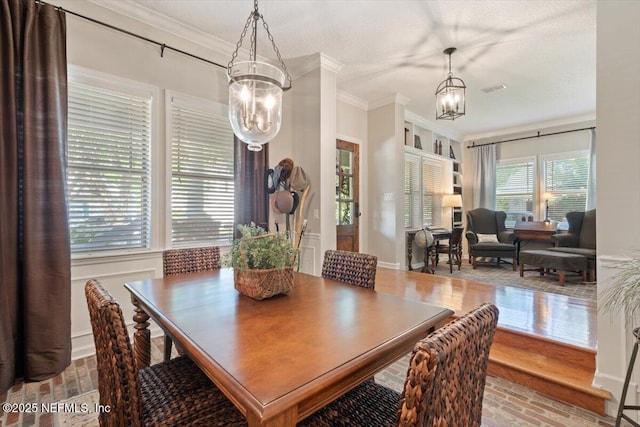 1060 Meadow View Ln, Saint Augustine, FL 32092 - dining space featuring a chandelier, brick flooring, and crown molding