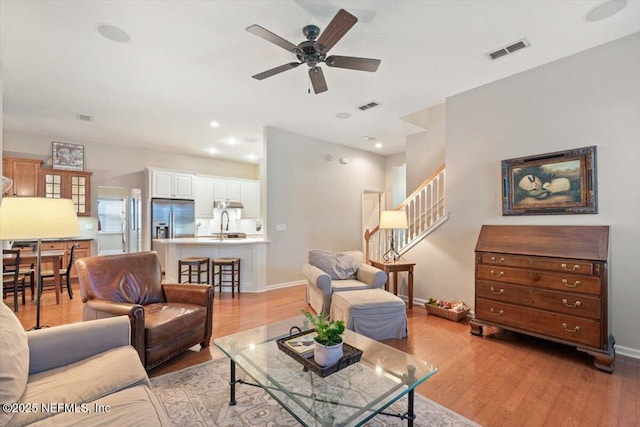 1060 Meadow View Ln, Saint Augustine, FL 32092 - living area featuring light wood-style flooring, ceiling fan, and stairway