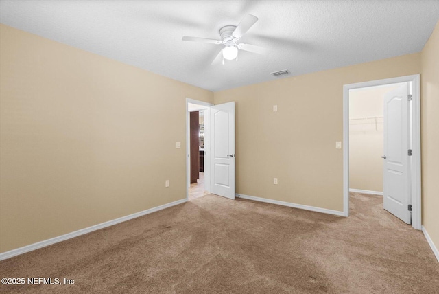 3728 W Florentine Dr, Citrus Springs, FL 34433 - unfurnished bedroom with a walk in closet, carpet, a closet, a ceiling fan, and a textured ceiling