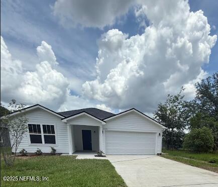 8045 Driggers St, Jacksonville, FL 32220 - ranch-style house with concrete driveway, an attached garage, and a front yard
