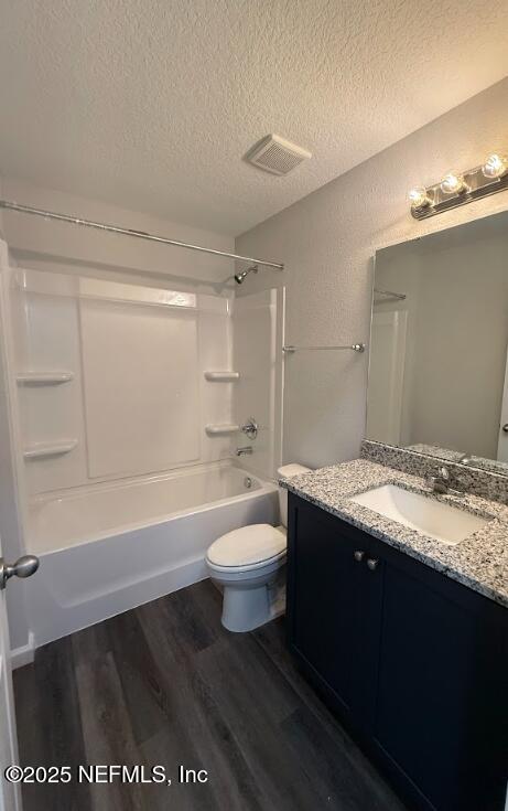 8045 Driggers St, Jacksonville, FL 32220 - full bathroom with a textured ceiling, vanity, wood finished floors, shower / bath combination, and a textured wall