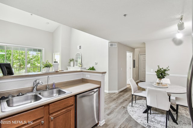 8550 Touchton Rd Unit 932, Jacksonville, FL 32216 - kitchen featuring stainless steel dishwasher, brown cabinets, light wood finished floors, and light countertops