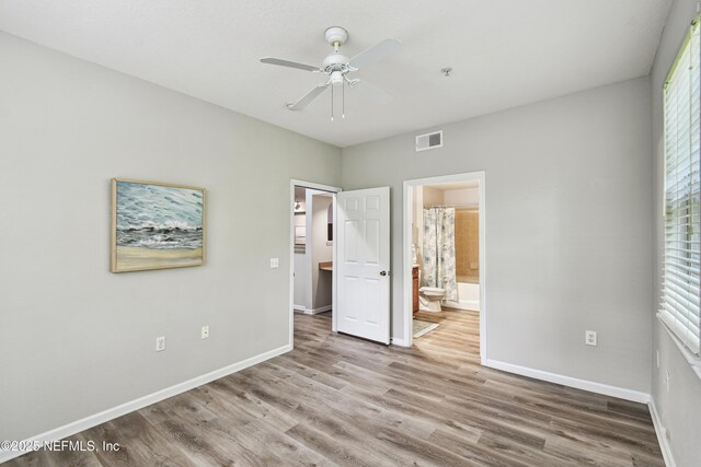 8550 Touchton Rd Unit 932, Jacksonville, FL 32216 - unfurnished bedroom with wood finished floors, ensuite bath, and a ceiling fan