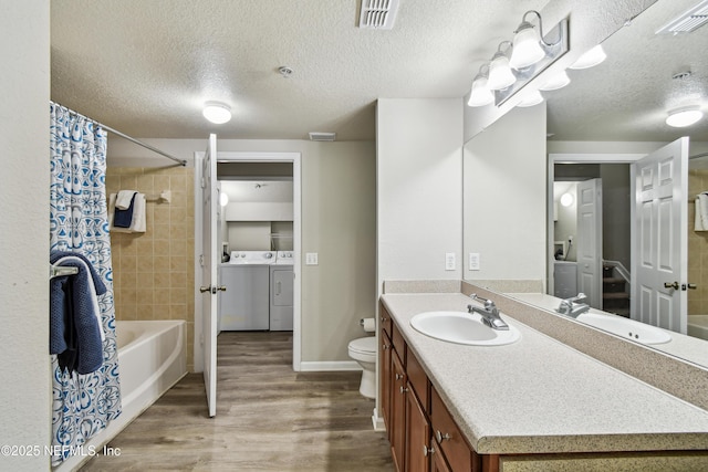 8550 Touchton Rd Unit 932, Jacksonville, FL 32216 - bathroom with separate washer and dryer, wood finished floors, vanity, shower / bath combo with shower curtain, and a textured ceiling