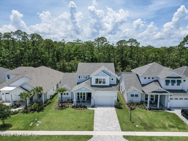 351 Palm Crst Dr, Ponte Vedra, FL 32081 - view of front of house with decorative driveway, a garage, a front lawn, and a forest view