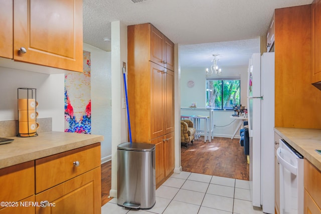 5811 Atlantic Blvd Unit 115, Jacksonville, FL 32207 - kitchen with white appliances, light countertops, light tile patterned floors, a chandelier, and a textured ceiling
