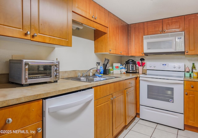 5811 Atlantic Blvd Unit 115, Jacksonville, FL 32207 - kitchen with white appliances, light tile patterned flooring, light countertops, and brown cabinetry