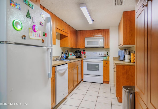5811 Atlantic Blvd Unit 115, Jacksonville, FL 32207 - kitchen featuring white appliances, light countertops, light tile patterned floors, and brown cabinetry