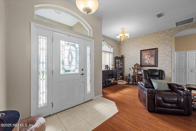 45 E Diamond Dr, Palm Coast, FL 32164 - foyer entrance with light wood finished floors and a chandelier