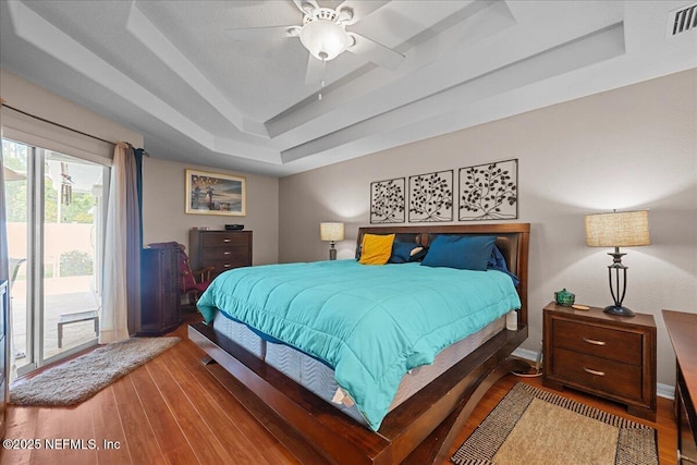 45 E Diamond Dr, Palm Coast, FL 32164 - bedroom with a tray ceiling, access to outside, wood finished floors, and ceiling fan