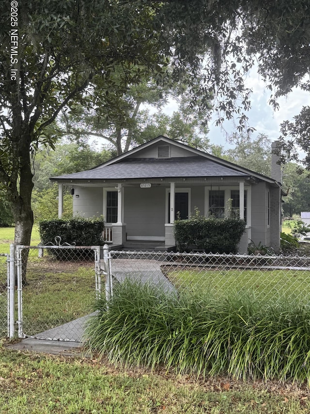 85215 Airplane Ln, Yulee, FL 32097 - bungalow-style home featuring a fenced front yard, a chimney, and covered porch