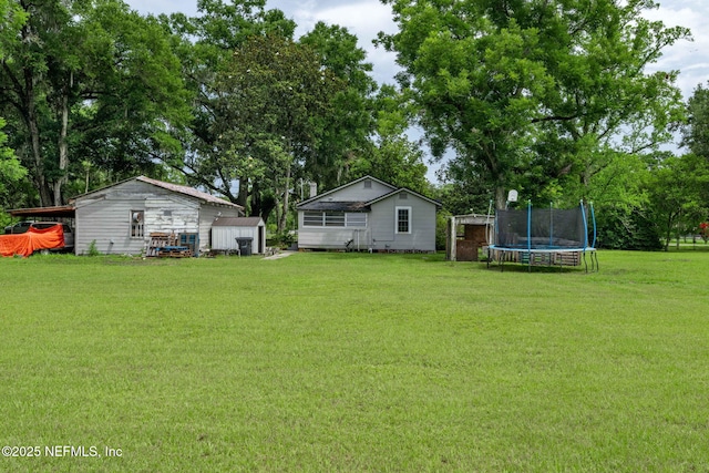 85215 Airplane Ln, Yulee, FL 32097 - view of green lawn with a trampoline, a shed, and view of wooded area