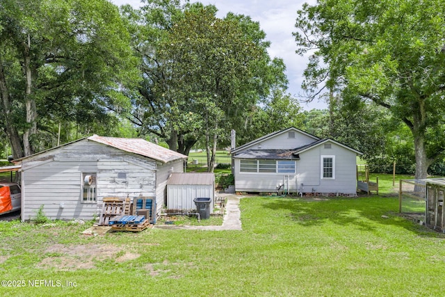 85215 Airplane Ln, Yulee, FL 32097 - back of property featuring a yard, an outbuilding, and view of scattered trees