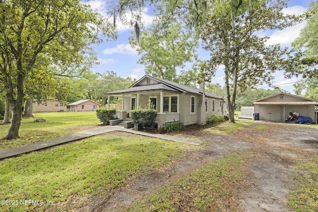 85215 Airplane Ln, Yulee, FL 32097 - view of front of house with a front yard, a detached carport, driveway, a chimney, and a porch