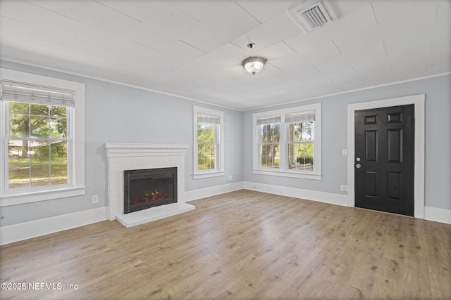 85215 Airplane Ln, Yulee, FL 32097 - unfurnished living room featuring plenty of natural light, wood finished floors, ornamental molding, and a brick fireplace