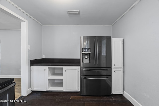 85215 Airplane Ln, Yulee, FL 32097 - kitchen featuring fridge with ice dispenser, ornamental molding, dark countertops, dark wood-type flooring, and white cabinets