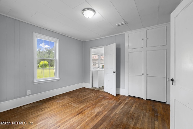 85215 Airplane Ln, Yulee, FL 32097 - unfurnished bedroom featuring dark wood finished floors and wood walls