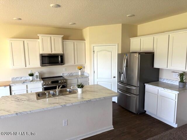 3432 Concord Ct, Green Cove Springs, FL 32043 - kitchen with appliances with stainless steel finishes, white cabinetry, a textured ceiling, light stone countertops, and dark wood-style flooring
