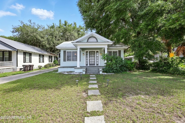 22 Marion St, Saint Augustine, FL 32084 - view of front of property featuring covered porch, a front yard, and a metal roof