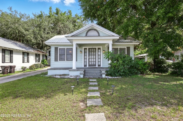 22 Marion St, Saint Augustine, FL 32084 - view of front of property with covered porch, a front lawn, and a metal roof
