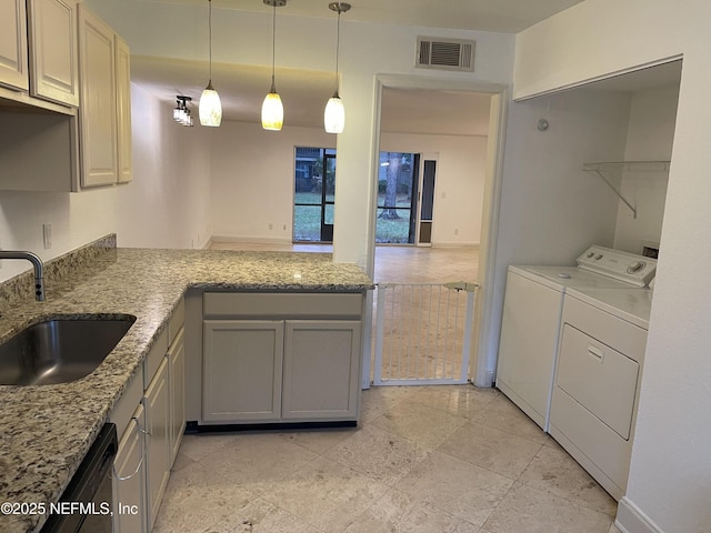 8880 Old Kings Rd S Unit 53, Jacksonville, FL 32257 - kitchen with washing machine and clothes dryer, light stone counters, decorative light fixtures, a peninsula, and gray cabinets