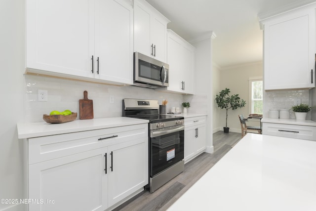 1114 Nantucket Ave, Jacksonville, FL 32233 - kitchen featuring appliances with stainless steel finishes, crown molding, light wood-type flooring, light countertops, and tasteful backsplash