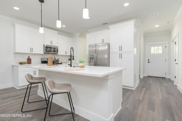 1114 Nantucket Ave, Jacksonville, FL 32233 - kitchen featuring appliances with stainless steel finishes, ornamental molding, wood finished floors, decorative backsplash, and white cabinetry