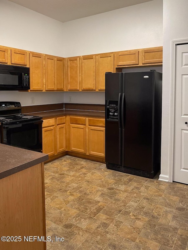 5151 Playpen Dr Unit 7-2, Jacksonville, FL 32210 - kitchen featuring black appliances, dark countertops, brown cabinets, and stone finish floors