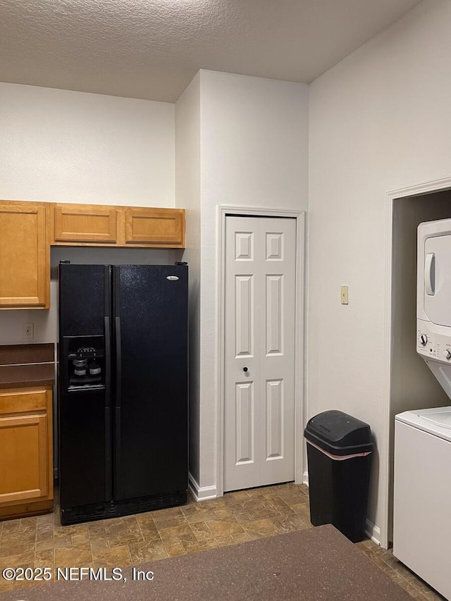 5151 Playpen Dr Unit 7-2, Jacksonville, FL 32210 - kitchen with black fridge, stacked washer / drying machine, stone finish flooring, and brown cabinets