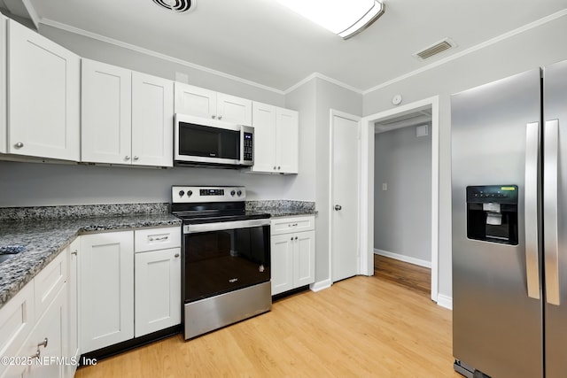 6552 Shady Oak Dr, Jacksonville, FL 32277 - kitchen with appliances with stainless steel finishes, light wood-style flooring, white cabinetry, ornamental molding, and dark stone countertops