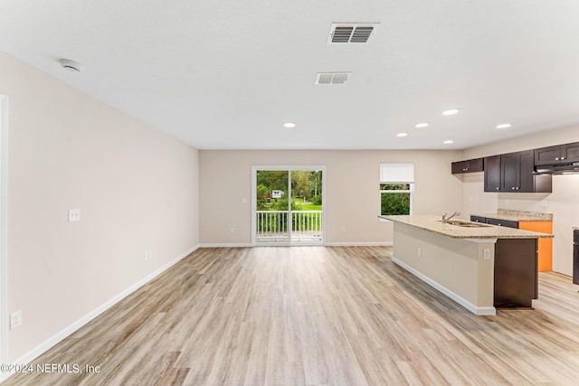 5428 Chenango Blvd, Jacksonville, FL 32254 - kitchen featuring light wood-style floors, extractor fan, recessed lighting, a kitchen island with sink, and light stone counters